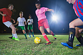 Young soccer players playing soccer at night