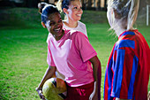 Playful, laughing young soccer plays at night