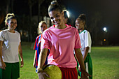 Portrait young soccer player with ball at night