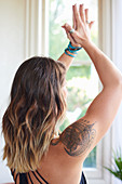 Woman with tattoo practicing yoga