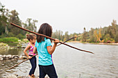 Girls fishing with sticks at lake