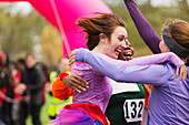 Enthusiastic female runners finishing charity run