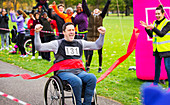 Man in wheelchair crossing finish line