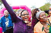 Enthusiastic female runners with medals cheering