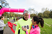 Happy couple runners hugging at finish line