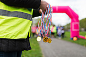 Volunteer holding medals at charity run