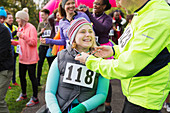 Man placing medal on woman in wheelchair