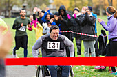 Man in wheelchair nearing race finish line