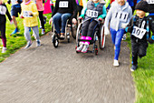 People in wheelchairs and runners moving