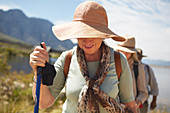 Active senior woman in sun hat hiking