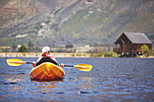 Senior man kayaking on sunny summer lake