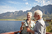 Smiling active senior couple drinking red wine