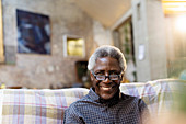 Portrait smiling, confident senior man on sofa