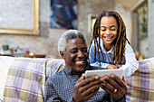 Grandfather and granddaughter using smart phone