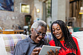 Daughter showing senior father how to use tablet