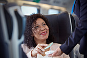 Smiling woman using contactless payment on train