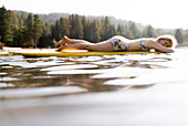 Serene woman laying on paddle board