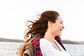 Smiling, carefree woman at windy lakeside