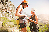 Female rock climbers preparing equipment