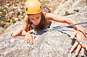 Focused, determined female rock climber