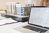 Digital blueprint on laptop next to model
