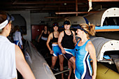Female rowing team preparing in boathouse