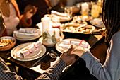 Family holding hands, praying at Christmas dinner