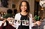 Portrait girl holding string of instant photos