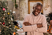 Portrait smiling senior man next to Christmas tree