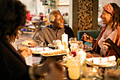 Family holding hands, praying at Christmas dinner