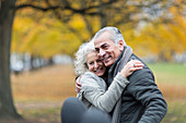 Happy senior couple hugging in autumn park