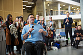 Audience clapping for male speaker in wheelchair