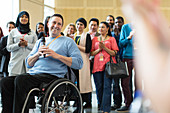 Audience clapping for male speaker in wheelchair