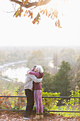 Affectionate senior couple hugging in sunny autumn park