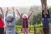 Confident, energetic seniors practicing yoga in park