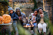 Grandparents and grandchildren enjoying campfire