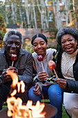 Family enjoying candy apples at campfire