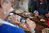 Senior woman photographing homemade pizza