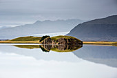 Rock formation in tranquil, placid ocean, Iceland