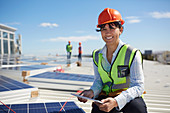 Engineer with digital tablet inspecting solar panels