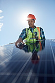 Engineer examining solar panel at sunny power plant