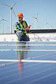 Engineer with equipment inspecting solar panels