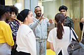 Male instructor leading teenagers in dance class studio