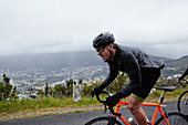 Determined male cyclist cycling on rainy road