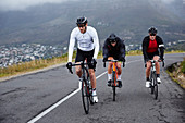 Dedicated male cyclists cycling on uphill road