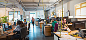 Creative business people working in open plan office