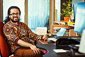 Portrait smiling creative businessman working at desk