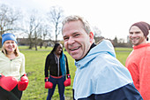 Portrait smiling man boxing with friends in park