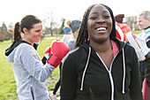 Portrait smiling woman boxing in park with friends
