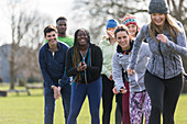 Team cheering woman running in park